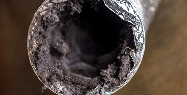 Dirty laundry flexible aluminum dryer vent duct-ductwork filled with lint and dust.