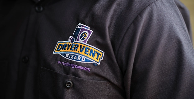 A closeup picture of a Dryer Vent Wizard branded work shirt.