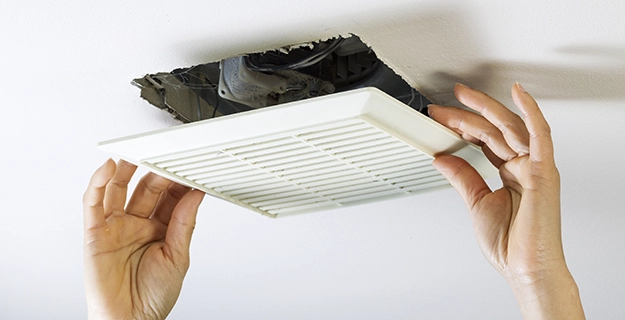 Removing bathroom fan vent cover.