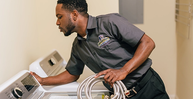 Technician holding a washing machine hose.
