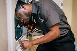 Technician looking inside of dryer.