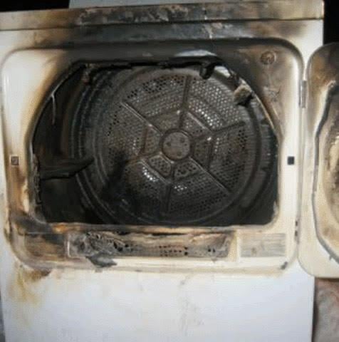 A burned dryer with a door open.