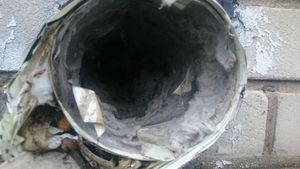 Lint coating the inside of a dryer vent line.
