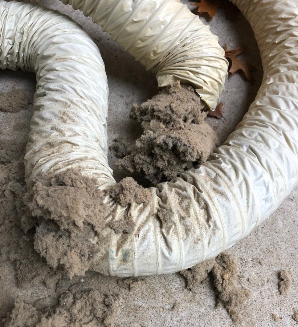 Vinyl dryer vent plugged with lint, which was removed from ceiling, and replaced with rigid dryer vent, in Detroit.