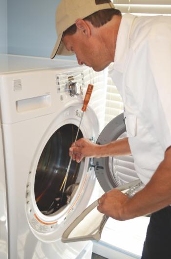 Dryer Vent Wizard technician cleaning an exterior vent 