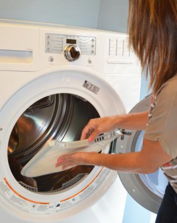 Woman cleaning off a dryer lint screen