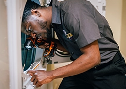 Technician cleaning out dryer.